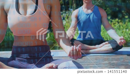 Practicing pair in orange crop and blue tank meditating on dock with yoga mats, binary overlay Practicing pair in orange crop and blue tank meditating on dock with yoga mats, binary overlay 141551140