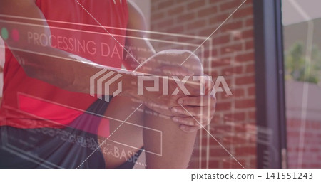 Clasping athlete in red tank top and dark shorts, sitting near brick wall, PROCESSING DATA overlay Clasping athlete in red tank top and dark shorts, sitting near brick wall, PROCESSING DATA overlay 141551243