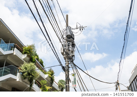 Close-up of Street utility poles in Harajuku, Shibuya, Tokyo, Japan. View of utility poles with blue sky background. Close-up of Street utility poles in Harajuku, Shibuya, Tokyo, Japan. View of utility poles with blue sky background. 141551700