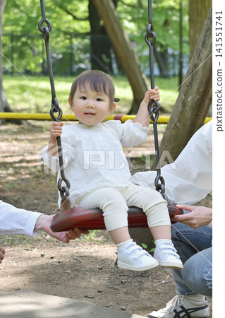 A little girl playing with a swing A little girl playing with a swing 141551741