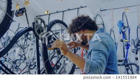 Repairing mechanic adjusting rear wheel and cassette on black bike in shop wall racks, denim-shirt Repairing mechanic adjusting rear wheel and cassette on black bike in shop wall racks, denim-shirt 141551984