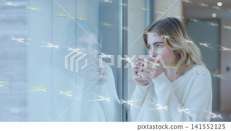 Cradling ceramic mug, woman wearing knit sweater standing at big window with reflection, copy space Cradling ceramic mug, woman wearing knit sweater standing at big window with reflection, copy space 141552125