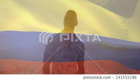 Standing man wearing patterned shirt on open rocky plain at golden hour, with tricolor flag overlay Standing man wearing patterned shirt on open rocky plain at golden hour, with tricolor flag overlay 141552196