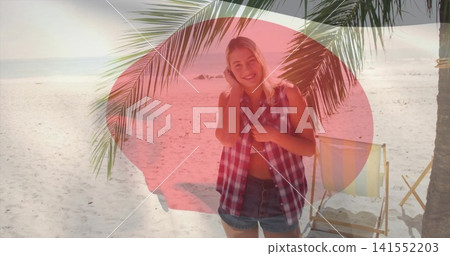 Smiling woman wearing denim shorts on white sand under palms, with striped chair and red overlay 141552203