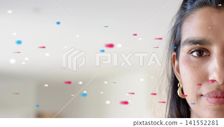Gazing mid-adult Indian woman holding gaze in studio, with gold hoop earring, confetti, copy space Gazing mid-adult Indian woman holding gaze in studio, with gold hoop earring, confetti, copy space 141552281