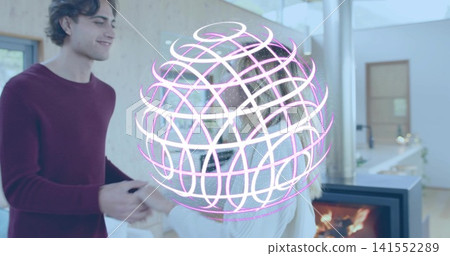 Holding hands, couple wearing maroon and white sweaters at home by fireplace with hologram overlay 141552289