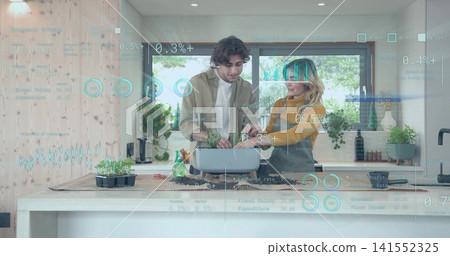 Women wearing mustard top, beige jacket planting seedlings, checking laptop in kitchen with AR HUD Women wearing mustard top, beige jacket planting seedlings, checking laptop in kitchen with AR HUD 141552325