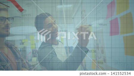 Writing designer in raglan shirt adding notes on glass wall at office with sticky notes, overlay Writing designer in raglan shirt adding notes on glass wall at office with sticky notes, overlay 141552534
