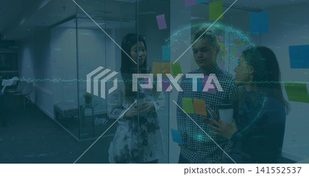 Discussing colleagues pointing at colorful post-its on glass partition in office, with hologram Discussing colleagues pointing at colorful post-its on glass partition in office, with hologram 141552537