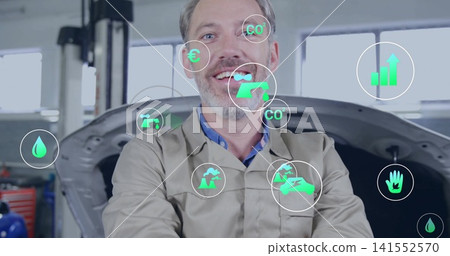Standing mechanic in beige coverall, blue shirt in garage, showing open hood car, tool chest, icons 141552570