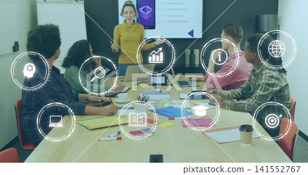 Presenting woman in mustard turtleneck gesturing toward seated team in conference room with laptops Presenting woman in mustard turtleneck gesturing toward seated team in conference room with laptops 141552767