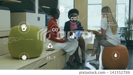 Discussing three women in business attire meeting in office lounge, with laptop tablet HUD overlays 141552789