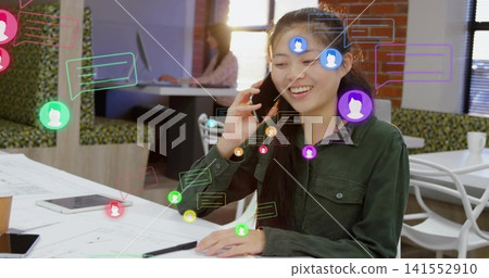 Smiling woman in green shirt holding smartphone, marking sketches in cafe, tablet, chat overlays Smiling woman in green shirt holding smartphone, marking sketches in cafe, tablet, chat overlays 141552910