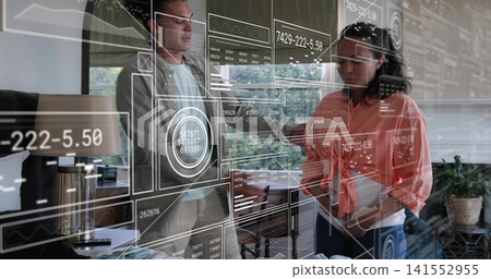 Reviewing data, two coworkers wearing light blazer and coral top at office glass wall, with tablet Reviewing data, two coworkers wearing light blazer and coral top at office glass wall, with tablet 141552955