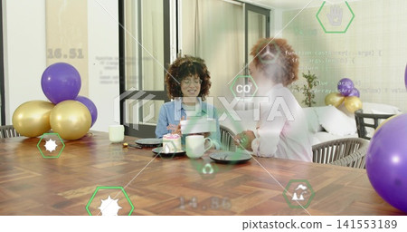 Smiling two women wearing denim shirt exchanging gift at home wooden table, with AR overlays Smiling two women wearing denim shirt exchanging gift at home wooden table, with AR overlays 141553189