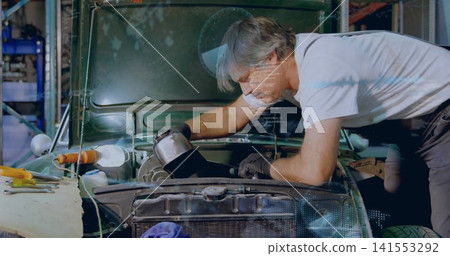 Leaning mechanic in white tee and suspenders pouring oil from metal can into engine bay, tools Leaning mechanic in white tee and suspenders pouring oil from metal can into engine bay, tools 141553292