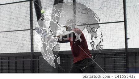 Swinging male in maroon top hitting bright yellow ball with racket on enclosed court, globe overlay Swinging male in maroon top hitting bright yellow ball with racket on enclosed court, globe overlay 141553432