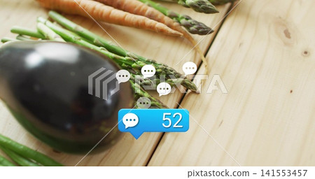 Displaying eggplant asparagus carrots on light wood table, with white speech icons and blue chat 52 Displaying eggplant asparagus carrots on light wood table, with white speech icons and blue chat 52 141553457