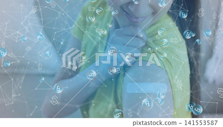 Smiling Korean woman in yellow top touching bandage on left arm in pale interior, bitcoin bubbles Smiling Korean woman in yellow top touching bandage on left arm in pale interior, bitcoin bubbles 141553587
