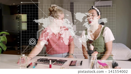 Applying makeup, friends in pink top and pinafore in bedroom, with palettes and digital map overlay Applying makeup, friends in pink top and pinafore in bedroom, with palettes and digital map overlay 141554002