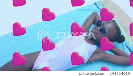 Reclining girl wearing one-piece and round sunglasses on turquoise towel by pool, heart-overlays Reclining girl wearing one-piece and round sunglasses on turquoise towel by pool, heart-overlays 141554019