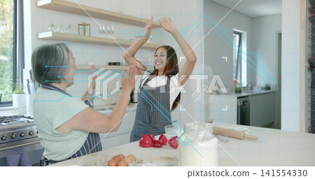 High-fiving mother and teen wearing aprons, preparing dough in home kitchen with flour jar, HUD High-fiving mother and teen wearing aprons, preparing dough in home kitchen with flour jar, HUD 141554330