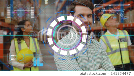 Standing supervisor in checkered shirt monitoring warehouse aisle, showing AR HUD, vests, hard hats Standing supervisor in checkered shirt monitoring warehouse aisle, showing AR HUD, vests, hard hats 141554477