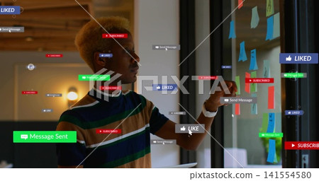Adjusting designer in striped shirt moving post-its on glass in office, holding tablet and overlays Adjusting designer in striped shirt moving post-its on glass in office, holding tablet and overlays 141554580