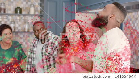 Cheering group of friends watching bearded man throwing colored powder in home kitchen, copy space Cheering group of friends watching bearded man throwing colored powder in home kitchen, copy space 141554647