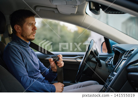 Man fastening seat belt in car Man fastening seat belt in car 141555019