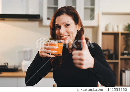 Woman preparing green smoothie in bright kitchen with fresh fruits and vegetables, healthy eating lifestyle moment in natural daylight Woman preparing green smoothie in bright kitchen with fresh fruits and vegetables, healthy eating lifestyle moment in natural daylight 141555360