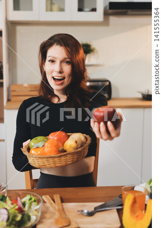 Woman preparing green smoothie in bright kitchen with fresh fruits and vegetables, healthy eating lifestyle moment in natural daylight Woman preparing green smoothie in bright kitchen with fresh fruits and vegetables, healthy eating lifestyle moment in natural daylight 141555364