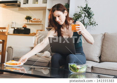 Woman preparing green smoothie in bright kitchen with fresh fruits and vegetables, healthy eating lifestyle moment in natural daylight Woman preparing green smoothie in bright kitchen with fresh fruits and vegetables, healthy eating lifestyle moment in natural daylight 141555383