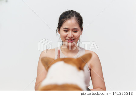 Asian woman training corgi dog with finger command at home Asian woman training corgi dog with finger command at home 141555518