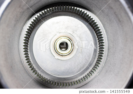 Close-up of an electric bicycle geared hub motor casing with a focus on the internal ring gear, metallic teeth, and visible traces of industrial lubricant for smooth operation 141555549