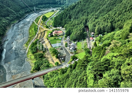 Aerial photograph capturing the gorge, suspension bridge, and railway bridge in Kawanehoncho, Shizuoka Prefecture. 141555976