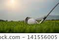 Golf clubs and balls on a green lawn in a beautiful golf course with morning sunshine. 141556005
