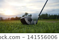 Golf clubs and balls on a green lawn in a beautiful golf course with morning sunshine. 141556006
