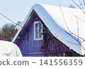 Vibrant purple country house facade, roof draped in thick white snow. Bright winter day, rural dacha charm 141556359