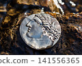 Ancient Greek coin with portrait on obverse washed by water, souvenir replica of ancient coin 141556365