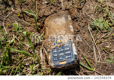 Old push-button telephone that has been lying in the ground for a long time Old push-button telephone that has been lying in the ground for a long time 141556374