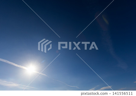 Bright sun shining in a clear blue sky with visible lens flare Bright sun shining in a clear blue sky with visible lens flare 141556511