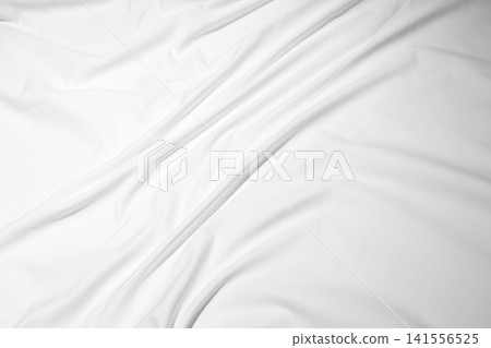 White wrinkled bed sheet with soft folds and subtle shadows White wrinkled bed sheet with soft folds and subtle shadows 141556525