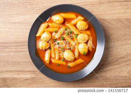 Tteokbokki with quail eggs, Korean spicy rice cake traditional food, table top view Tteokbokki with quail eggs, Korean spicy rice cake traditional food, table top view 141556717