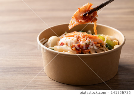 Eating instant noodle soup with kimchi, bok choy, champignon mushroom, quail egg and Tteokbokki Eating instant noodle soup with kimchi, bok choy, champignon mushroom, quail egg and Tteokbokki 141556725