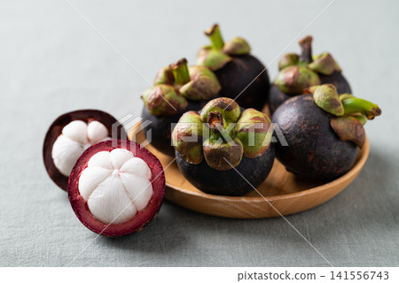Fresh mangosteen on wooden plate, Tropical fruit in Thailand Fresh mangosteen on wooden plate, Tropical fruit in Thailand 141556743