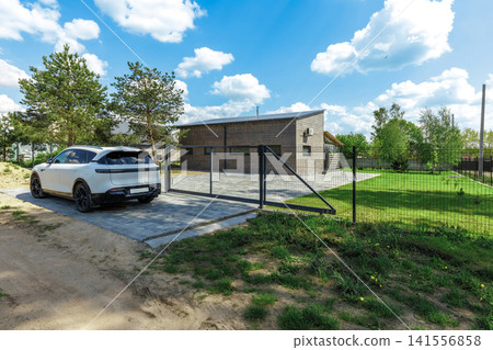 Modern Country House with White Car parked at Yard Gate Modern Country House with White Car parked at Yard Gate 141556858