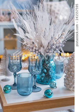 Festive Coffee Table Setup with Blue Glassware and Floral Decor Festive Coffee Table Setup with Blue Glassware and Floral Decor 141557595