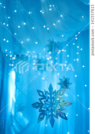 Hanging Metallic Snowflakes on Glowing Blue Bokeh Background Hanging Metallic Snowflakes on Glowing Blue Bokeh Background 141557615