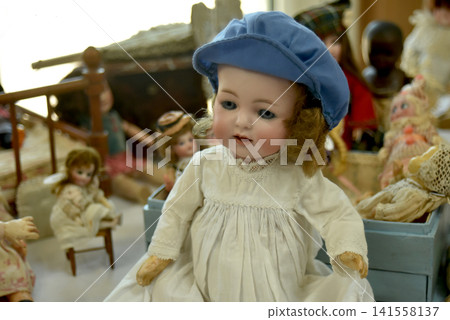 Beautiful retro porcelain doll displayed among vintage objects at a flea market, capturing a nostalgic atmosphere with antique decoration and childhood memories. Beautiful retro porcelain doll displayed among vintage objects at a flea market, capturing a nostalgic atmosphere with antique decoration and childhood memories. 141558137